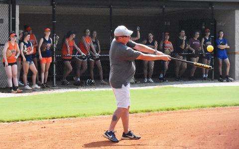 Lady Raiders coach Bill Bradley leads the team through fielding drills Thursday morning while players watch from the dugout. CODY ROGERS/Staff