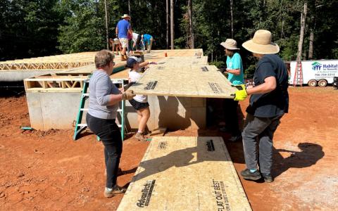 Connie Post, Susan Wilkin, Addie Aycock and Elaine Manglitz work to construct the Combs Family’s home in Demorest. BRIAN WELLMEIER/Staff 