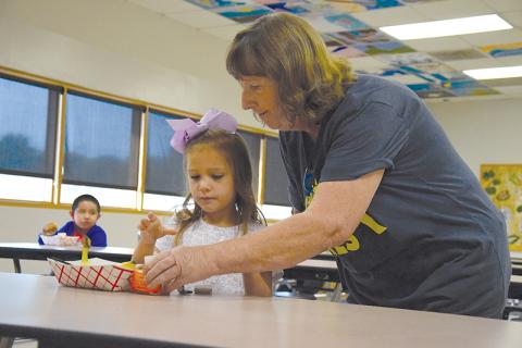 Above, Clarkesville Elementary custodian JoAnn Oliver helps kindergartener Lily Ellison get her breakfast. SAMANTHA SINCLAIR/CNI News Service