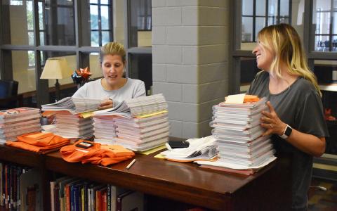 Habersham Central teachers Kelli Holland and Dr. Kathleen Addison pick up their first day packets and shirts in the media center Monday afternoon. School starts for students Friday. MATTHEW OSBORNE/Staff 