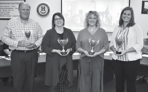 Principals Rodney Long of Baldwin Elementary, Dr. Connie Franklin of the Ninth Grade Academy, Marybeth Thomas of Wilbanks Middle School and Aimee Shedd of Hazel Grove Elementary accept their attendance awards for August at Monday’s Board of Education meeting. MATTHEW OSBORNE/Staff