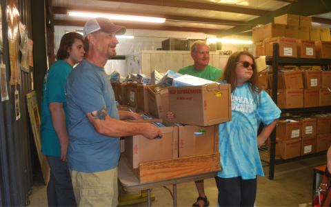 From left, volunteers Micah Hunnicutt, Gary Burton, Rick Chaffin and Austin Clarke prepare to deliver food to families Wednesday night. BRIAN WELLMEIER/Staff