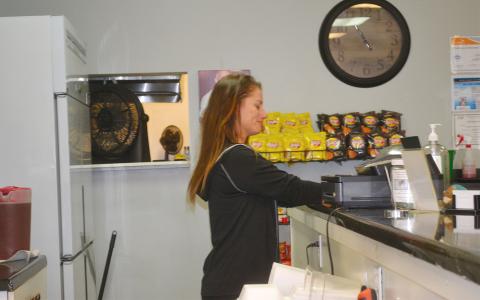 Michelle Smith works behind the counter at Side Street Deli in Cornelia. BRIAN WELLMEIER/Staff