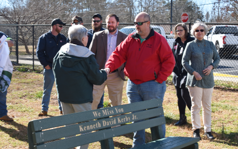 City Manager Donald Anderson, shown shaking hands with Susan Russell, and others celebrate the planting of a new Dogwood tree and commemorate longtime resident and frequent park attendee Kenneth David Kerby Jr., who passed away last year. AMARIS E. RODRIGUEZ/Staff