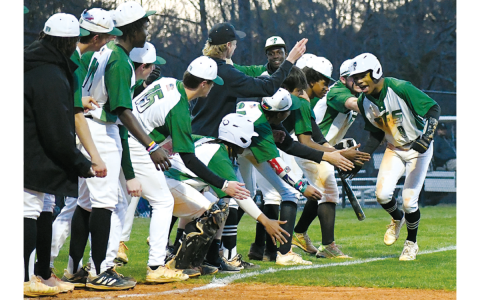 Malique Charlton runs through the line of low-fives before touching home plate. He hit one of the many TFS home runs in their win over region rival George Walton last Thursday. CODY ROGERS/Staff