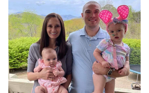 Corey Roberts holds his 2-year-old daughter, Sarah, as his wife Ranae smiles with baby Anna. The Roberts family, who attends Foundations Academy, said they are grateful that Sarah is halfway through her chemotherapy. SUBMITTED