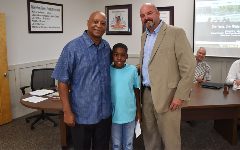 Fifth-grader Logan Canada was recognized by the Board of Education for his heroic act that saved his grandfather Victor Scott’s life earlier this year. From left are Scott and Canada with Superintendent Matthew Cooper. AMARIS E. RODRIGUEZ/Staff
