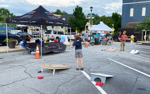 A family plays corn hole in the town square. YVONNE MARINELLI/Staff