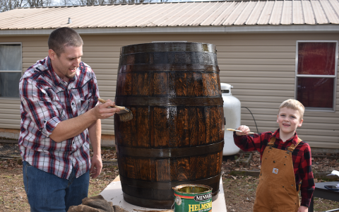Daniel Rusk and his son Cainan work on one of the barrels that have become a family hobby. BRIAN WELLMEIER/Staff