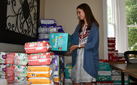Family Support Specialist Campbell Wiedemeier arranges assortments of diapers at FRC’s location on Washington Street. BRIAN WELLMEIER/Staff