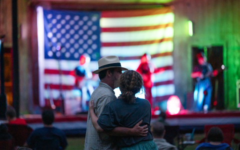 A local couple dancies in the light of the stage during a slow song at Red, White and Tunes on Friday night in Clarkesville. The event included food, fun and fireworks for anyone who had a little more patriotic juice flowing and needed an extra celebration. ZACH TAYLOR/Special