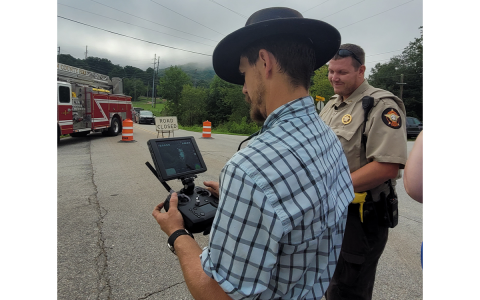 Rabun County Search and Rescue (SAR) Chief Will McCracken utilizes an Unmanned Aircraft System (UAS) drone to take pictures and investigate the area of a crash where a commercial vehicle carrying “blasting agents” overturned on its side early Tuesday morning at Kellys Creek Road in Rabun Gap. Also pictured is RCSO Corporal Jeffrey Hooper working the scene with other emergency personnel. MEGAN BROOME/The Clayton Tribune