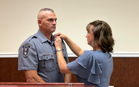 April Jones pins her husband Chris Jones with the new rank of Baldwin Police Chief. BRIAN WELLMEIER/Staff