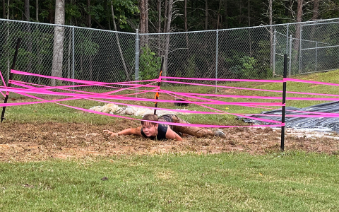 Pictured is SHMS eighth grade student Caden Free navigating the mud pit crawl.