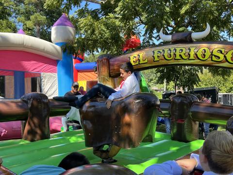 Jonah Maldonado, a local fifth grader, rides a mechanical bull at the festival, which also had bouncy houses for the entertainment of children who attended. AMARIS E. RODRIGUEZ/Staff