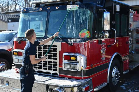 Habersham County Firefighter Isaac Koshiol scrubs the front of the firetruck at Station 12 on Duncan Bridge Road after returning from a call Thursday morning. JOHN DILLS/Staff