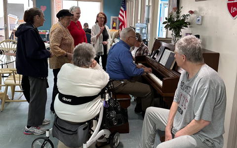 Michael Dunagan plays the piano alongside Jeff Kozyra on the cajón as patrons (from left) Cona Rider, Virginia Ross, Phyllis York, Peggy Jackson and Myra Hemphill gather around. SUBMITTED