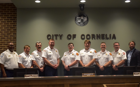 From left, Fire Chief Billy Joe Jenkins, Jr., Capt. Drake Meister, Capt. Dustin Henson, Capt. Lee Humphrys, Lt. Michael Hall, Lt. Matthew Williams, Lt. Chris Bruce, Division Chief/Fire Marshal Josh Hazle and Mayor John Borrow gather after the ceremony Tuesday. EMMA MARTI/Staff
