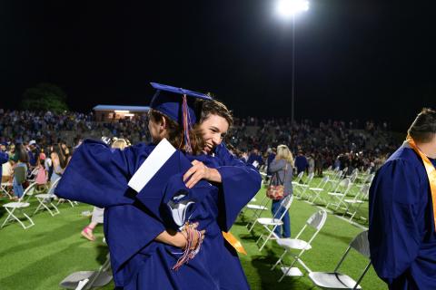 Habersham Central seniors Dan Griswold and Cody Thomas hug while parents and siblings rush the field to find their graduates. ZACH TAYLOR/Special