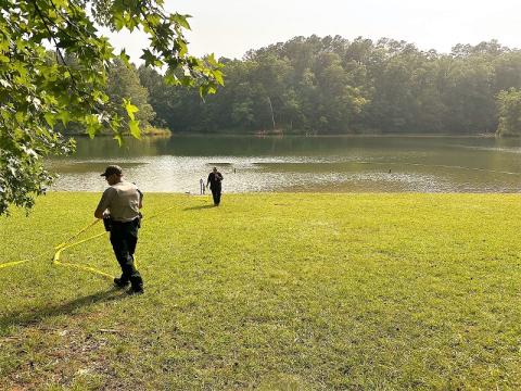 Personnel from the Georgia Department of Natural Resources Law Enforcement Division and Habersham County Emergency Services remove the tape the yellow tape that had marked the operational area during Saturday afternoon’s incident in the swimming area at Lake Russell Beach near Mt. Airy. HABERSHAM COUNTY/Submitted