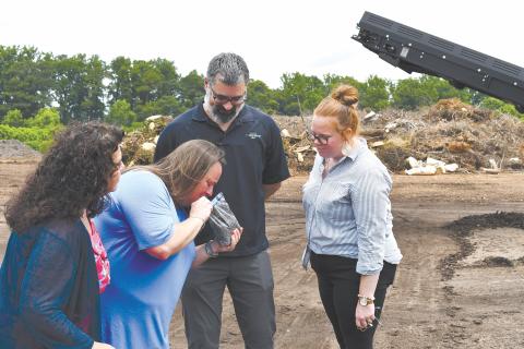 Baldwin Councilwoman Stephanie Almagno, Mayor Alice Venter, ReveSolutions Owner Carlos Talbott and Baldwin Chief Administrative Officer Emily Woodmaster take a moment to smell the compost end-product from the Athens-Clarke County Solid Waste Department. JOHN DILLS/Staff