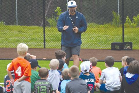 Raiders varsity coach Chris Akridge addresses the campers who braved the rain Thursday. LANG STOREY/Staff