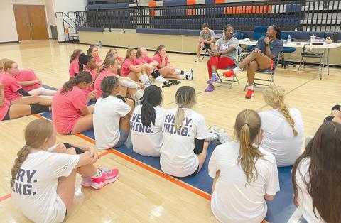 Volleyball professionals Lauren Ford and Santita Ebangwese (seated at right) impart wisdom to the campers.