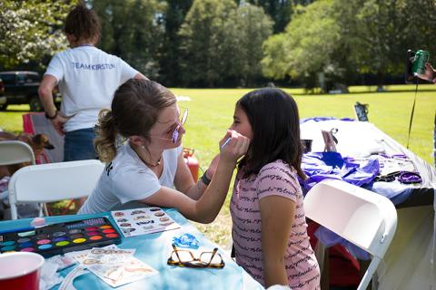 Kirsten Stephens paints a cat on Jeansly Contreras at the Children Affected by Addiction event in Pitts Park on Saturday. ZACH TAYLOR/Special
