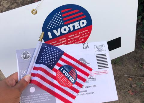 A photo of a voting sticker with a mail advertisement. UNSPLASH PHOTO