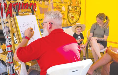 Graysen and Brandy Armour sit down for a caricature drawn by Jim Humphrey of Giggles and Grins Caricatures. ZACH TAYLOR/Special