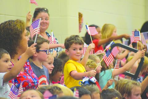 McCoy Malcom (center) joins his classmates in waving Old Glory to celebrate the Hometown Heroes at Fairview Elementary on Monday afternoon. MATTHEW OSBORNE/Staff