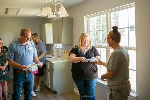 Owner of the most recent Habitat for Humanity home, Lisa Thomas (right), presents Jennifer Payne (center) a Bible and well wishes for her new home. ZACH TAYLOR/Special