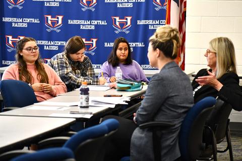 From left, Habersham Central High School students Sarah Wheeler, Brook Scherer, and McKenzie Smith listen and take notes while Attorneys Rebecca James, left, and Suzanne Boykin, right, teach them about objections. JULIANNE AKERS/Staff