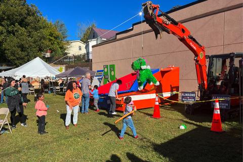 Children take whacks at a pinata at the Baldwin Fall Festival on Saturday. The fun party favor was hanging from a city excavator which was flanked by Stephanie Almagno for Mayor signs. CITY OF BALDWIN/Submitted