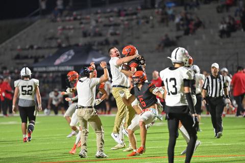 Habersham Central assistant coach Brandon Worley embraces Hayden Gailey (10) in the pandemonium following Gailey’s game clinching interception in double overtime on Friday night against Jackson County. TOM ASKEW/Special