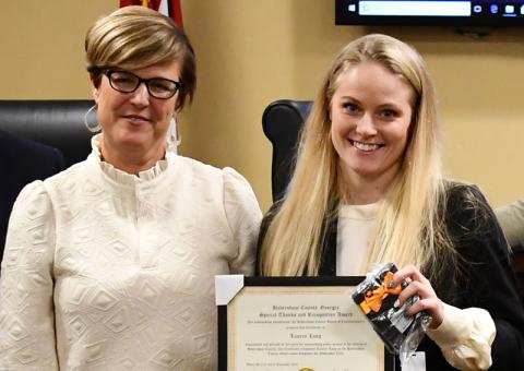 Lauren Long (right), shown being honored by County Manager Alicia Vaughn last year, has been writing grants for the county for 15 months. FILE 