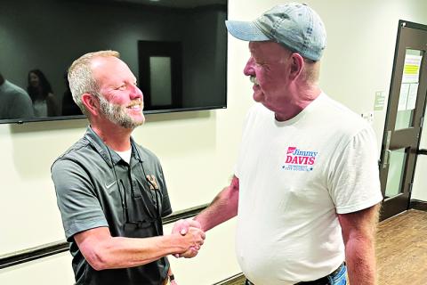Demorest Councilmen Donnie Bennett and Jimmy L. Davis congratulate each other on wining their council races at the elections office Tuesday night. MATTHEW OSBORNE/Staff