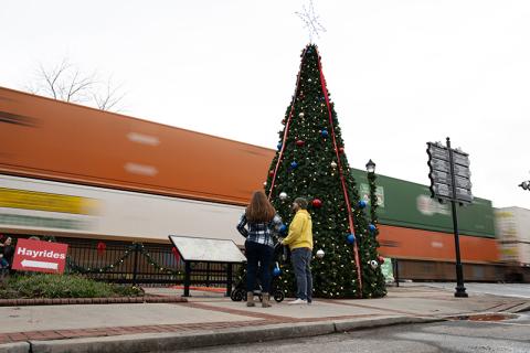 In typical Cornelia fashion, a train rolls by as Chris and Alicia Baratki stand next to the Christmas tree. ZACH TAYLOR/Special