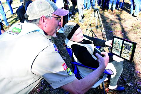 Scout Troop 5 Assistant Scoutmaster Alan Baker looks at a framed handbook page given to Alice Roseman that was left in the ground by her son Travis when he completed his Eagle Scout project in 1985. MATTHEW OSBORNE/Staff