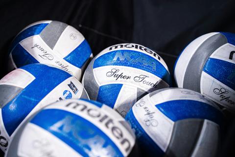 Volleyballs sit in a catch bin waiting to be used. UNSPLASH
