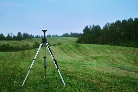 Land surveyor in a field. Valerie V/UNSPLASH