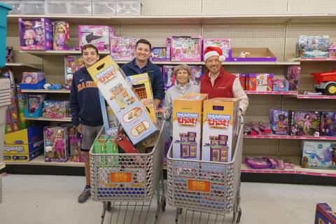 Carson Crane, Habersham Kiwanis Club President Brad Crane,  Habersham Kiwanis Club Secretary Nellie Snyder and Habersham Kiwanis Club Honorary Member Clay Christie stand behind full shopping carts for a photo. ZACH TAYLOR/Special