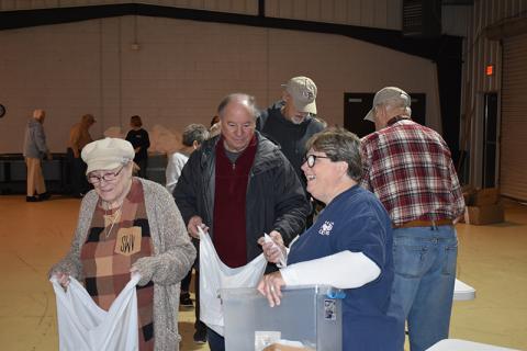 From left, Stella Ward, Bob Cook, Sam Watkins and Renè Grant work to fill the bags to be delivered to the schools later in the day. At far right is Richard Monroe. MATTHEW OSBORNE/Staff