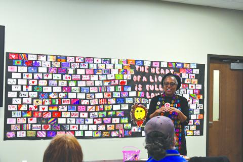 Audrey Davenport speaks in front of artwork by local school children to draw inspiration for the upcoming Tim Loves Tink mural. JULIANNE AKERS/Staff