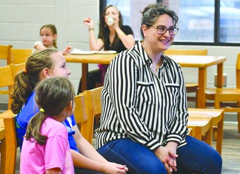 Author and illustrator Shanda McCloskey, right, chats with sisters Adalee and Ansley Guess about her books at Wilbanks Middle School on April 18. JULIANNE AKERS/Staff