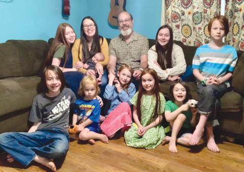 Randy and Mackenzie Chester are shown with their nine children Rosie, Paloma, Kells, Remy, Heidi, Azalea, Rune, Haven and Ezra.