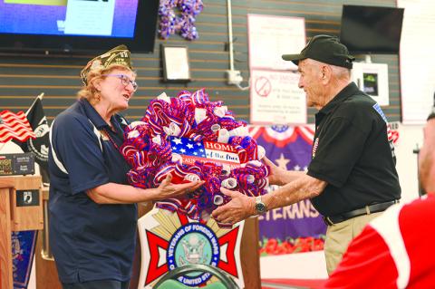 VFW Post 7720 Adjutant Connie Barrow gifts Andy Negra a wreath that reads “Home of the free because of the brave.” ZACH TAYLOR/Special