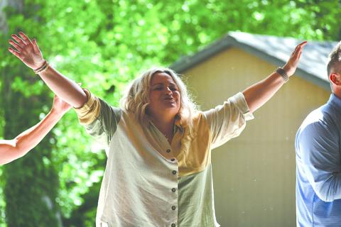 Kayla Ginn raises her hands during a gathering in Demorest. JULIANNE AKERS/Staff