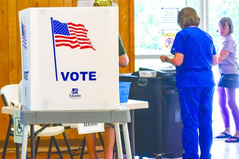 Poll workers cast ballots at Mud Creek Precinct during Tuesday’s election. Scan above for election results. JULIANNE AKERS/Staff