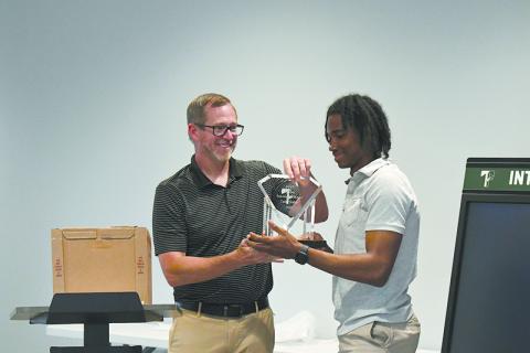 TFS coach Justin Pollock presents Indians’ catcher Caden Walker with the team’s MVP award at the banquet Tuesday. LANG STOREY/Staff